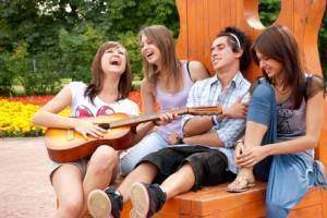Four young  friends play the guitar